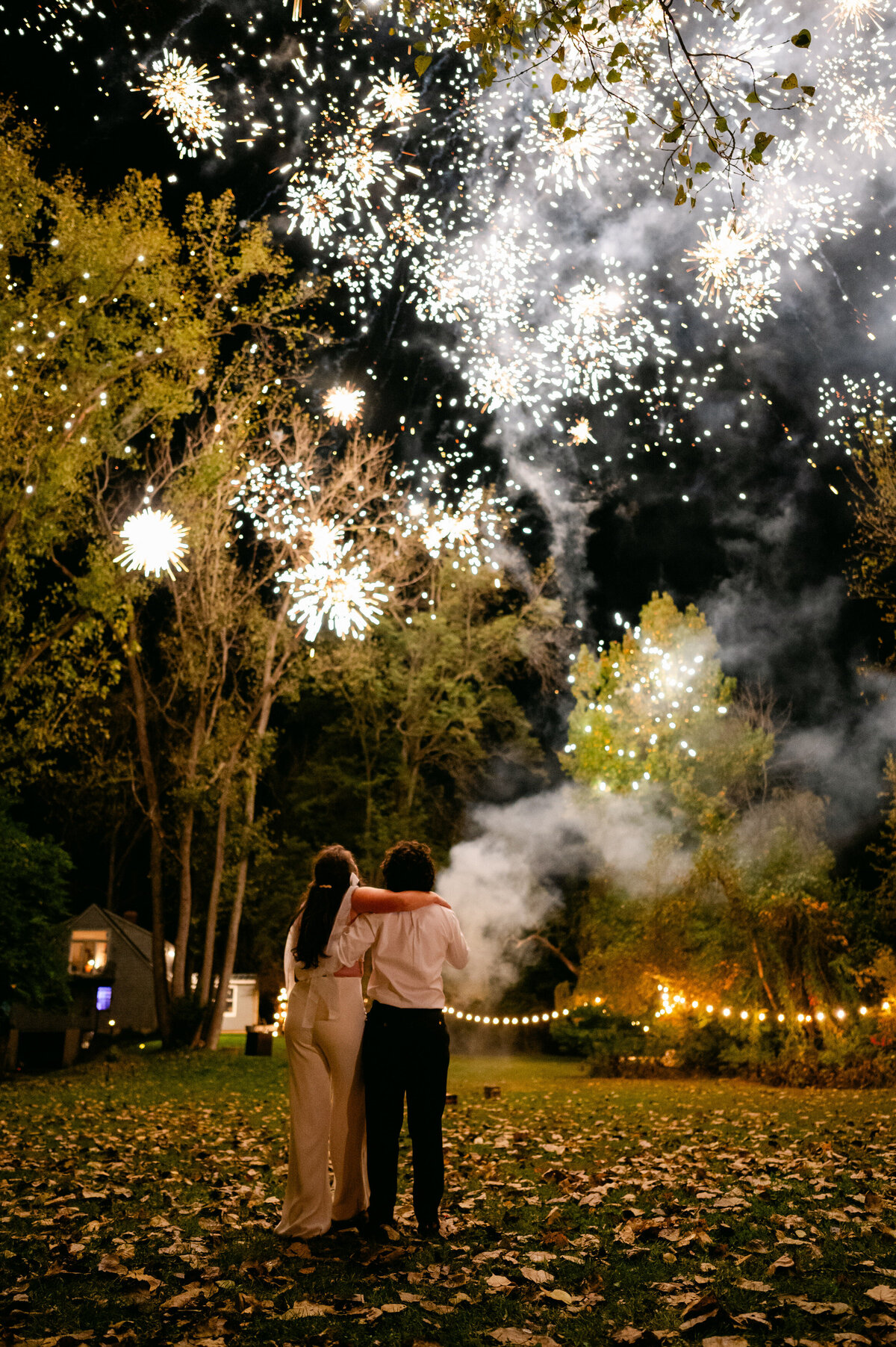 Bride and groom looking up at fireworks