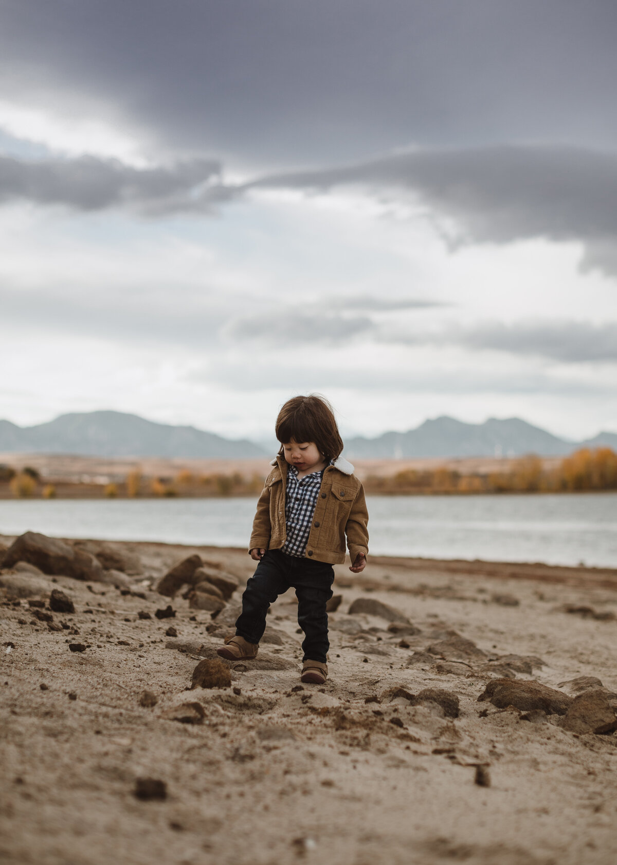 child playing on the beach in the fall