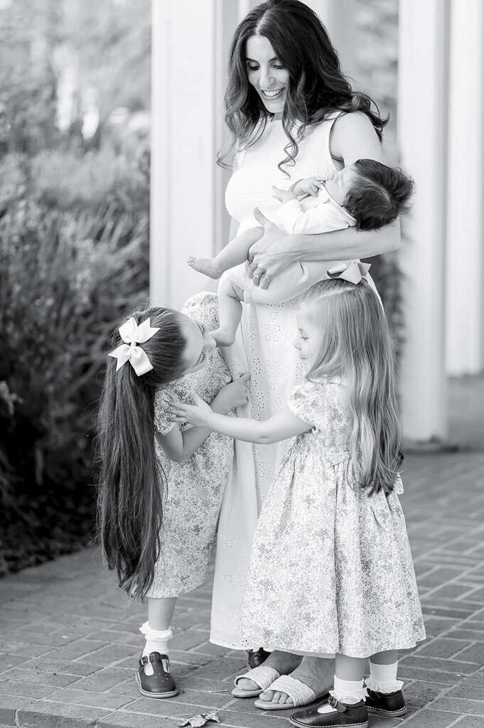 Black and white image of a mother and her 3 children on a porch
