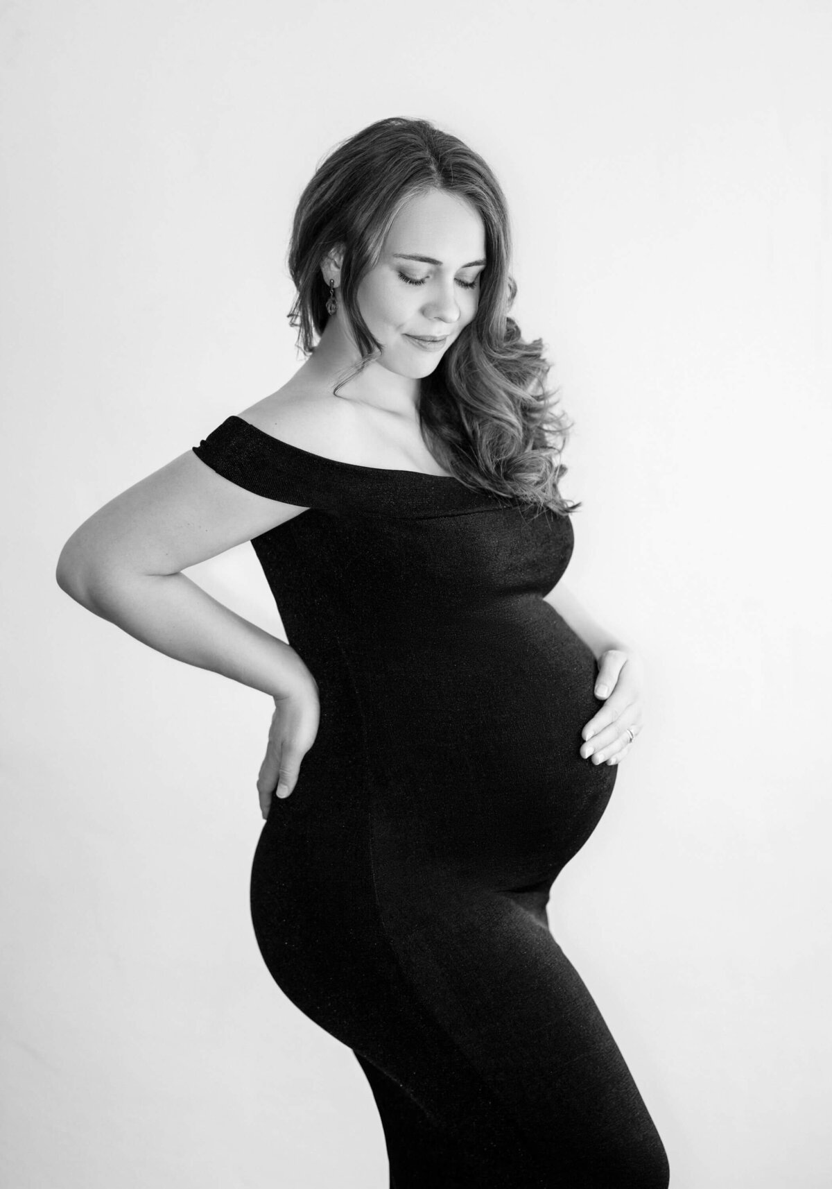 Stylish maternity portrait in black dress.