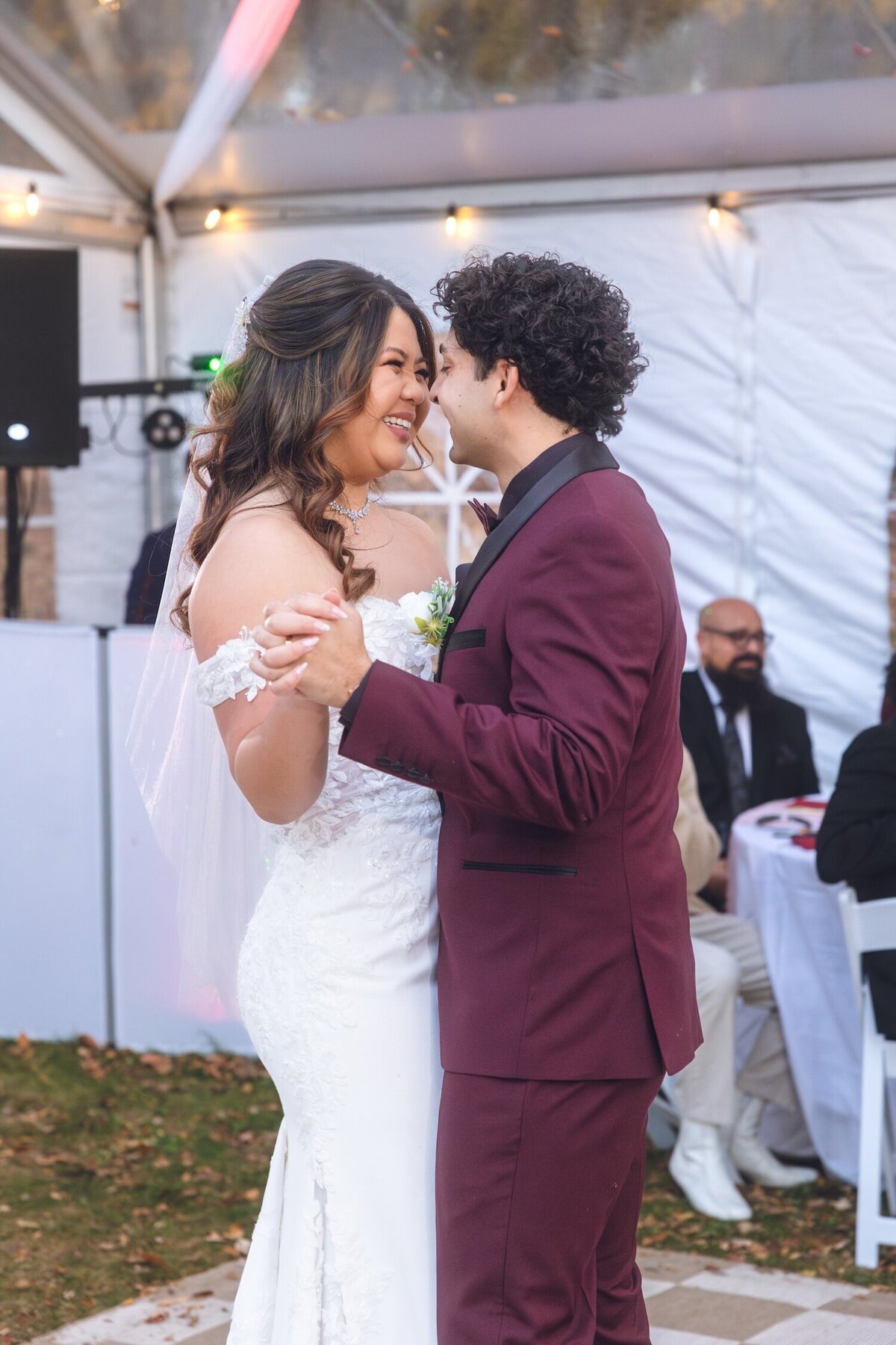 Bride and groom sharing their first dance under the reception tent.