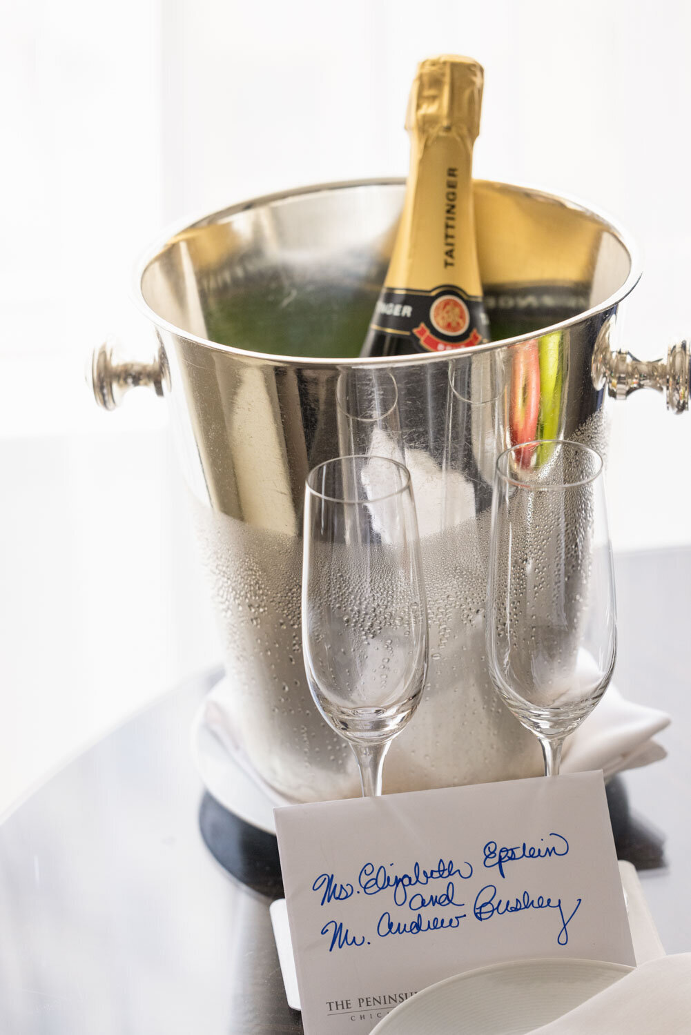 A bucket of taittinger champagne sits on a table
