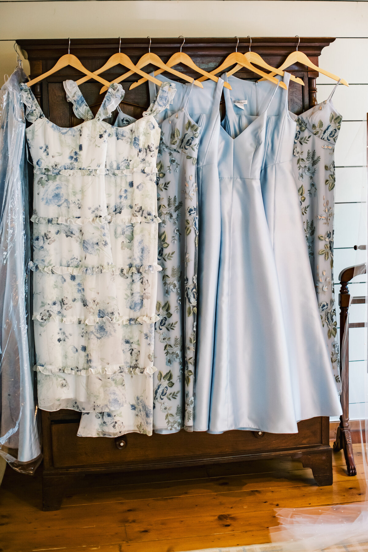 Soft blue and floral bridesmaid dresses hanging in bridal suite at Old Edwards Inn wedding in Highlands, North Carolina.