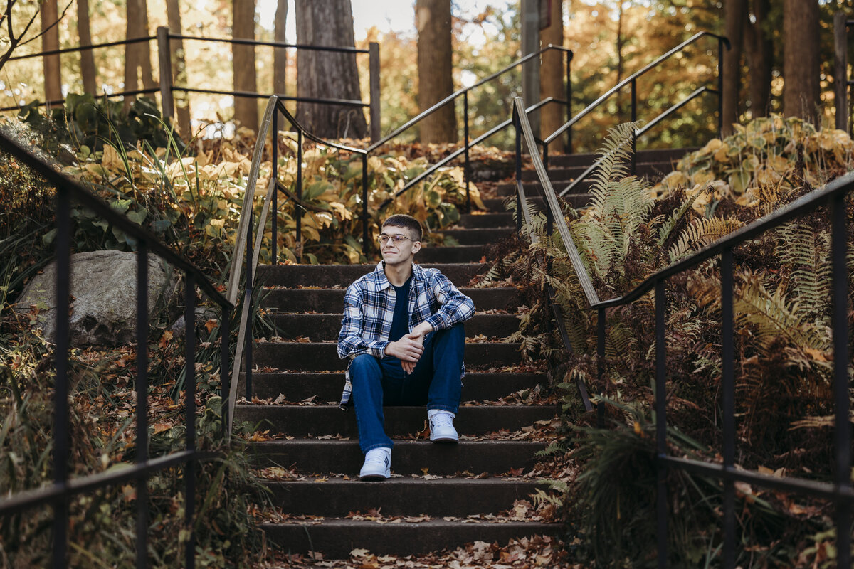 Senior boy sitting on steps at Spring Grove Park.