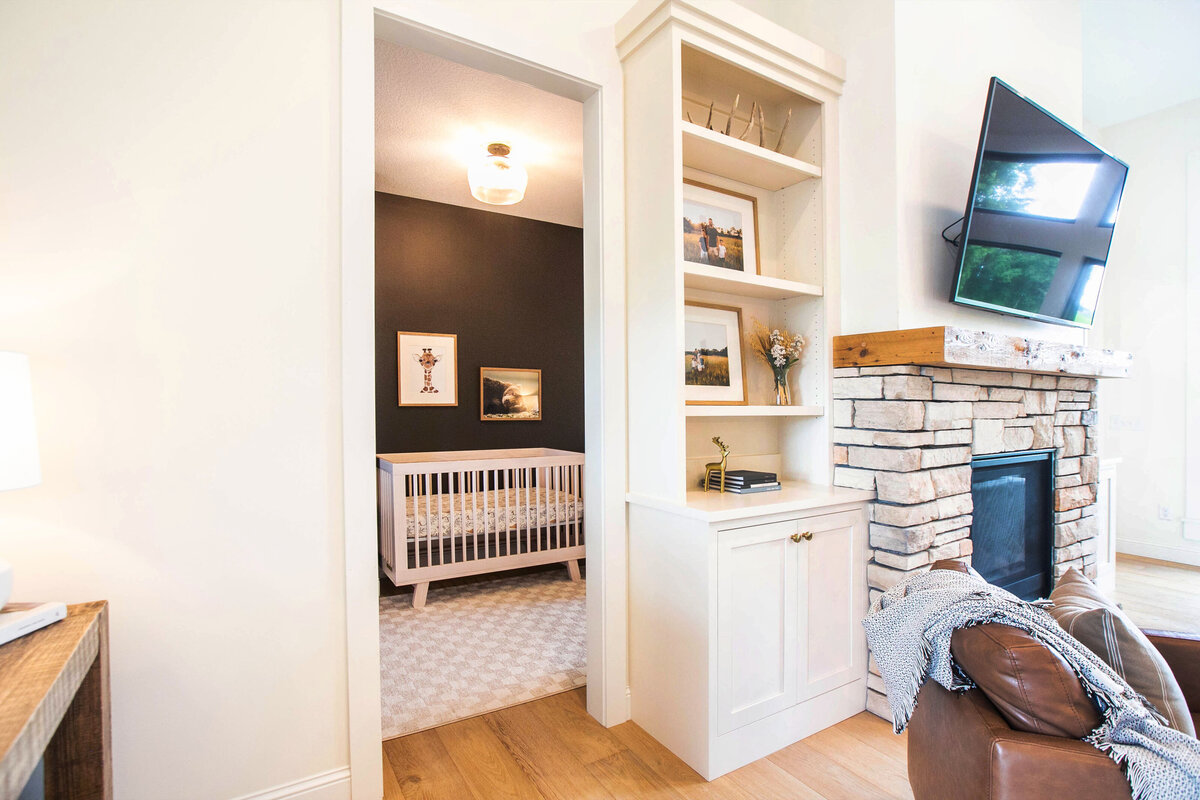 Custom nursery nook in Otsego home with dark walls, wood floors and modern accents designed by Cornerstone Custom Builds