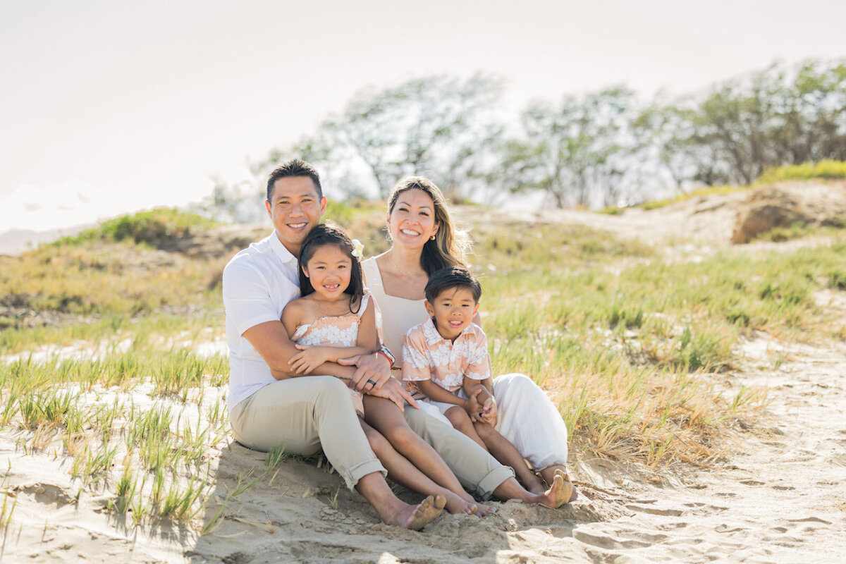 Photo of family sitting in the beach grass in Hawaii