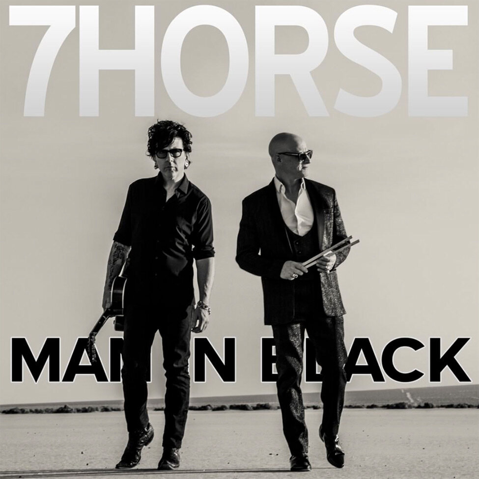 Single Cover Title Man In Black Band 7horse two members walking in desert both wearing black one holding guitar the other holding drumsticks