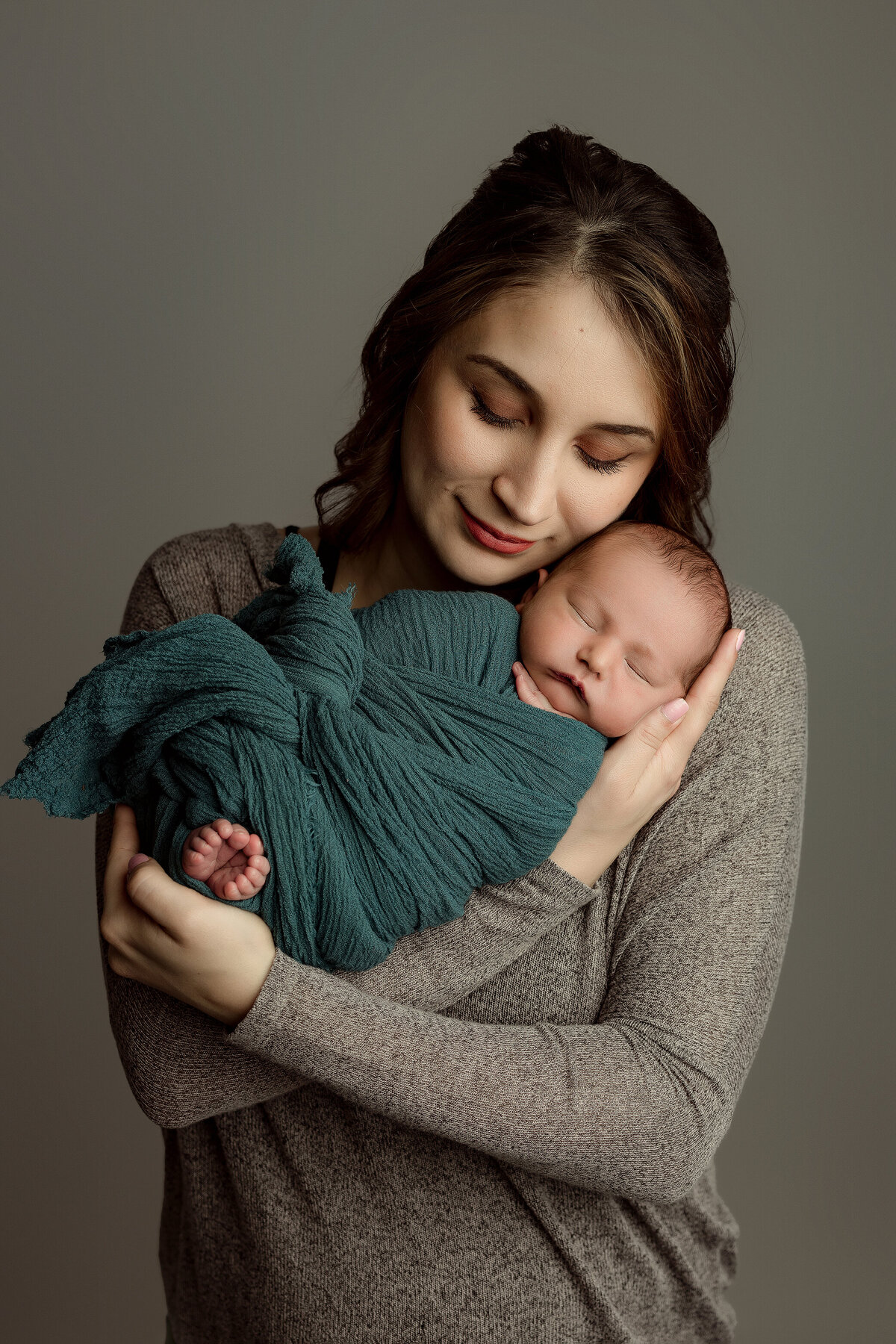 mom holding newborn baby in kalispell photographer studio
