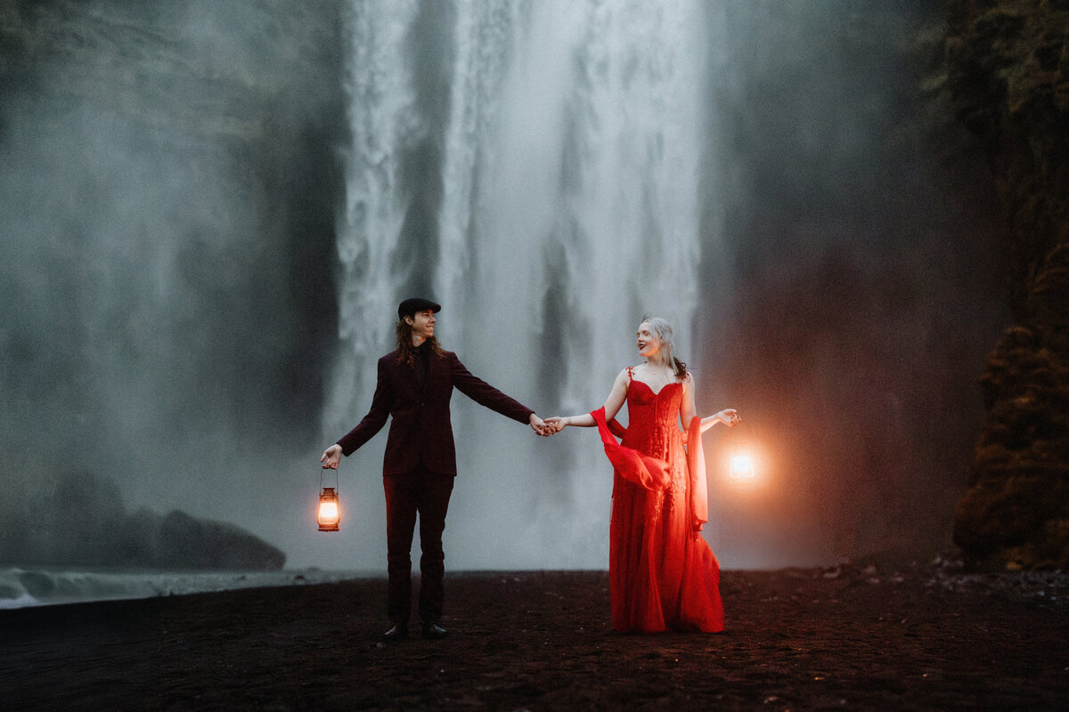 On the edge of a volcanic crater, a couple stands hand in hand, their love as enduring as the ancient lava fields beneath them.