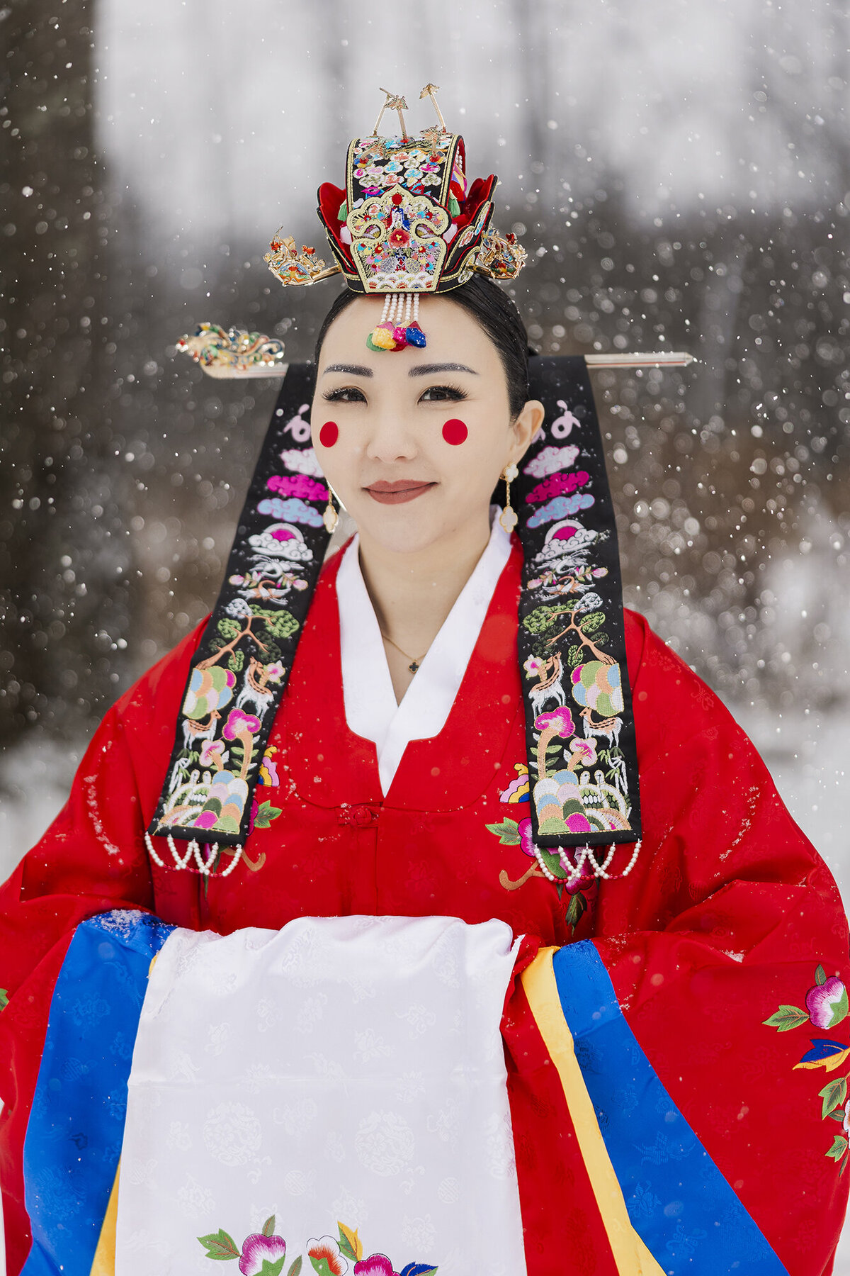 Bridal portrait in traditional Korean wedding hanbok and headpiece in the snow