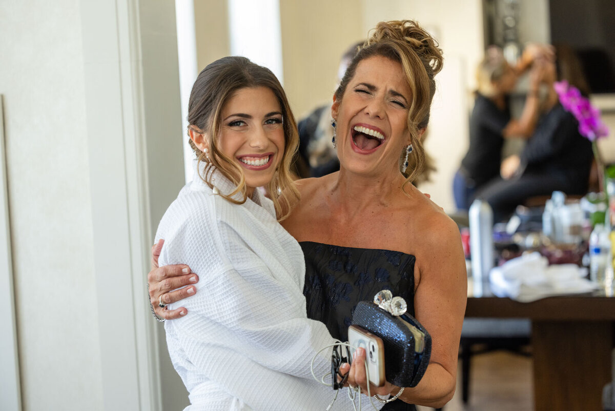 A woman in a white robe is hugging another woman in a black dress