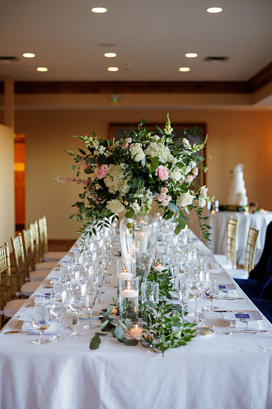 White and pink tall floral arrangement with candles and greenery at the Broadmoor Hotel.