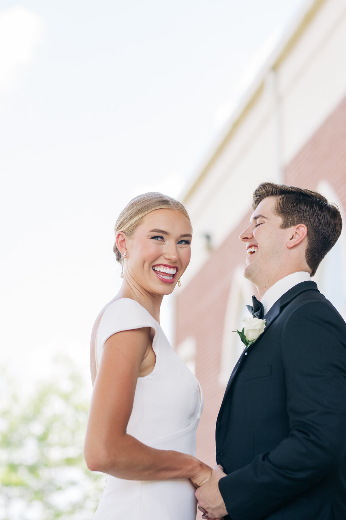 Couple laughing at each other outside a church