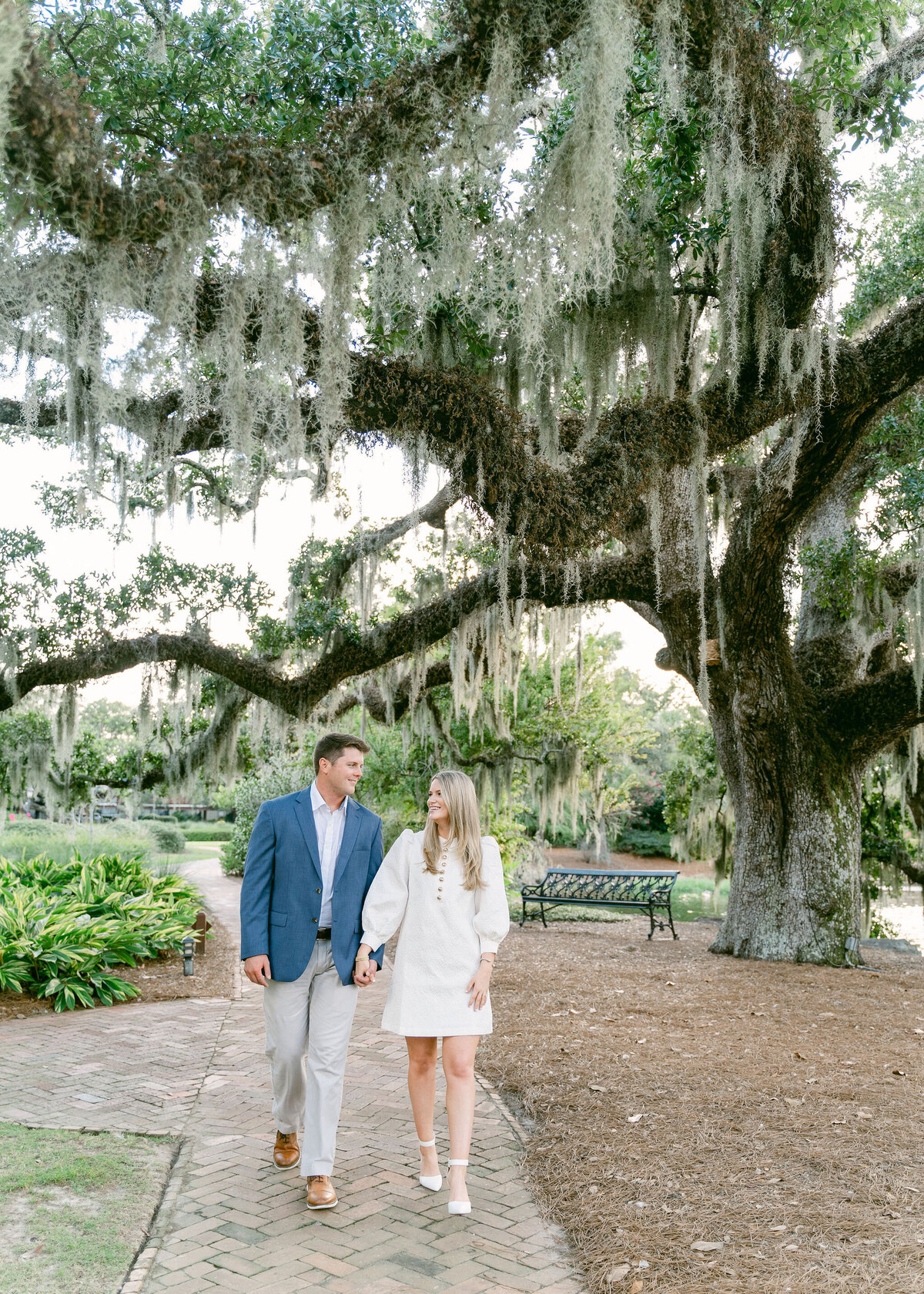 couple walking by a tree with Spanish moss