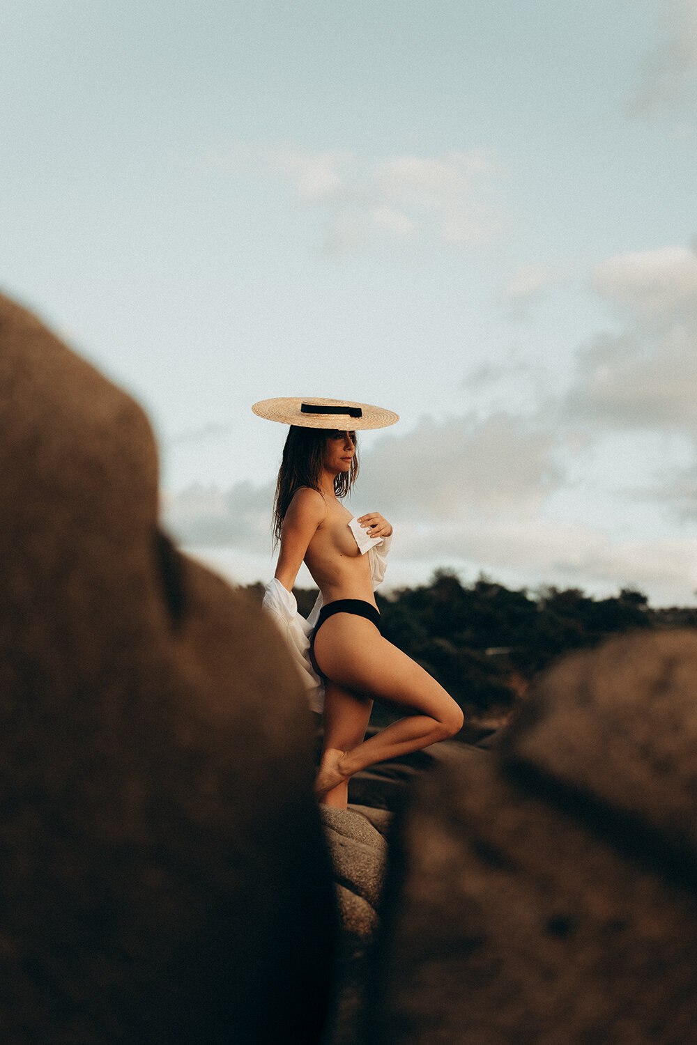 Topless model wearing a hat and swimsuit at a beach on the Sunshine Coast during a personal brand photography session