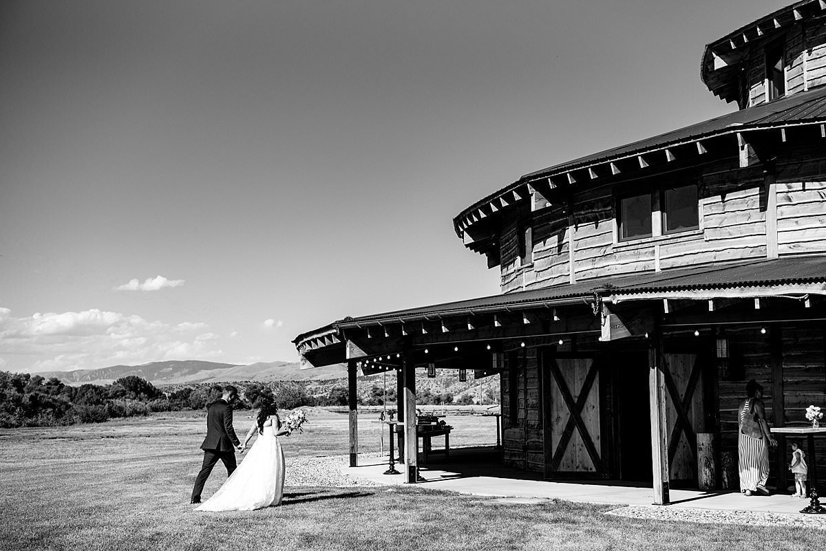 Black and white photo of couple walking  into the round barn at Headwaters Ranch
