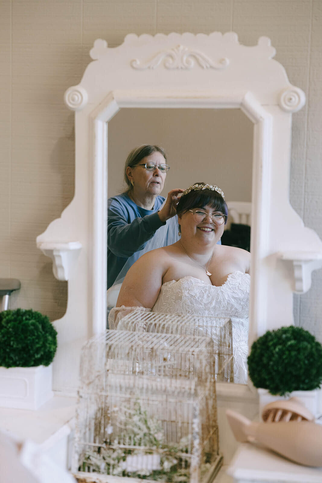 A bride getting her hair pieced placed on her head, representing the moments of joy shared between family.