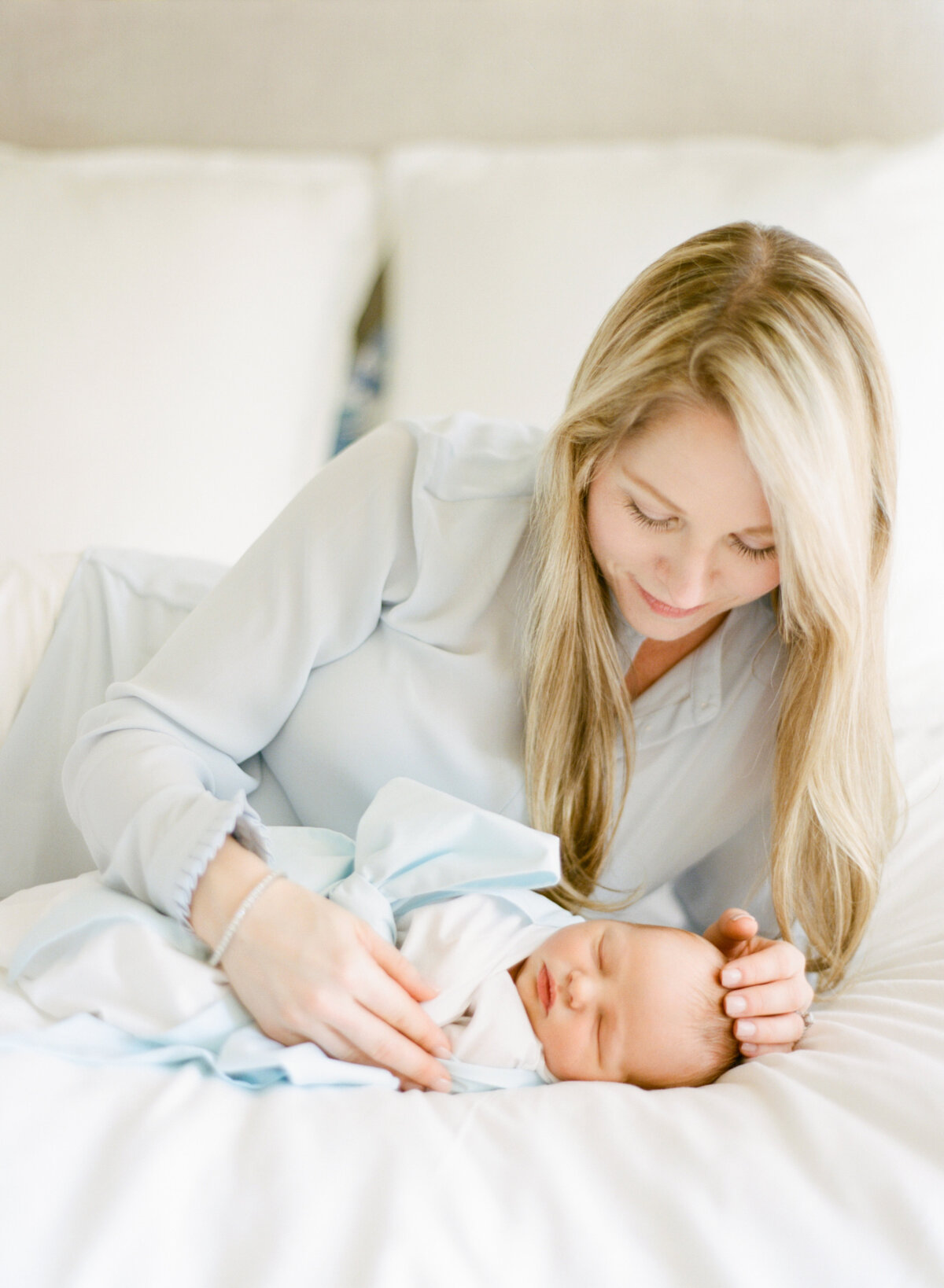Mom snuggles her newborn close during a newborn session. Image by Raleigh newborn photographer A.J. Dunlap Photography.