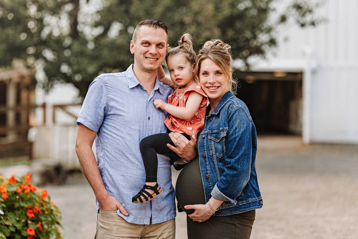 Classic portrait of a family of three in Bellevue, WA, smiling warmly at the camera during a family photo session.
