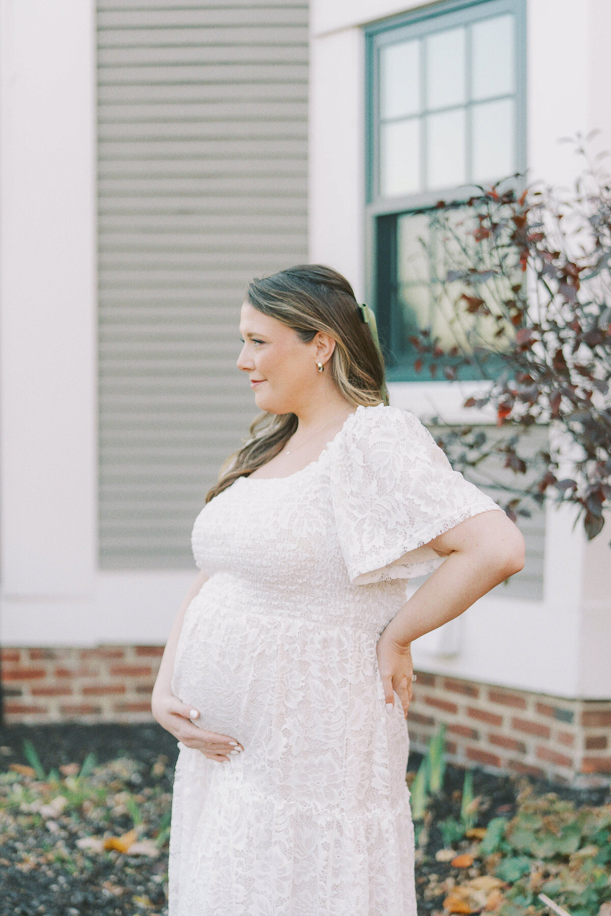 pregnant mom looking out as she poses for maternity photo