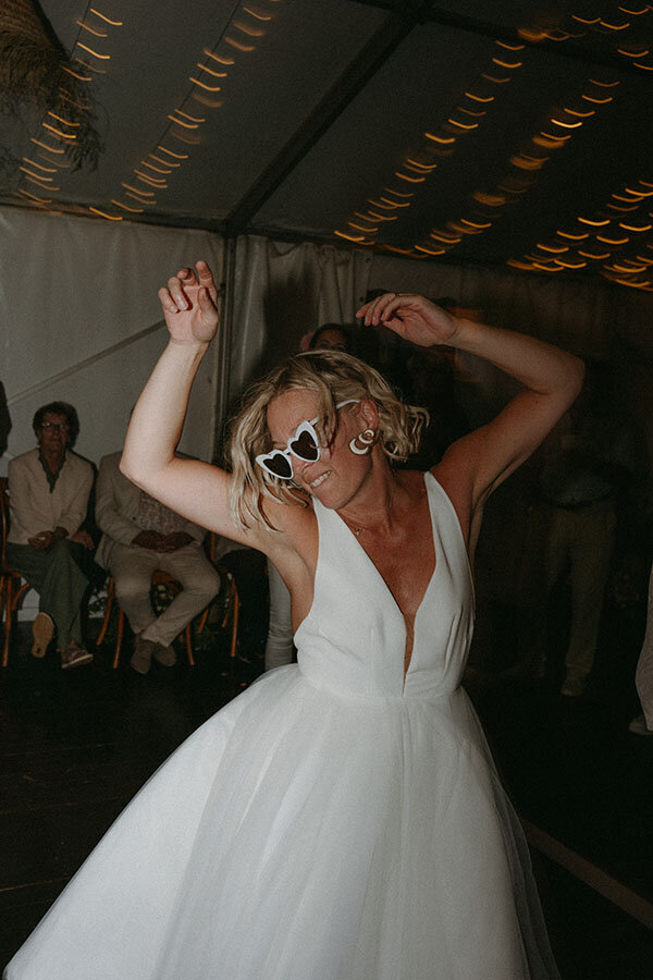 Gwladys sur la piste de danse, bras levés, sourire aux lèvres. Instant festif capturé par Kamescop.
