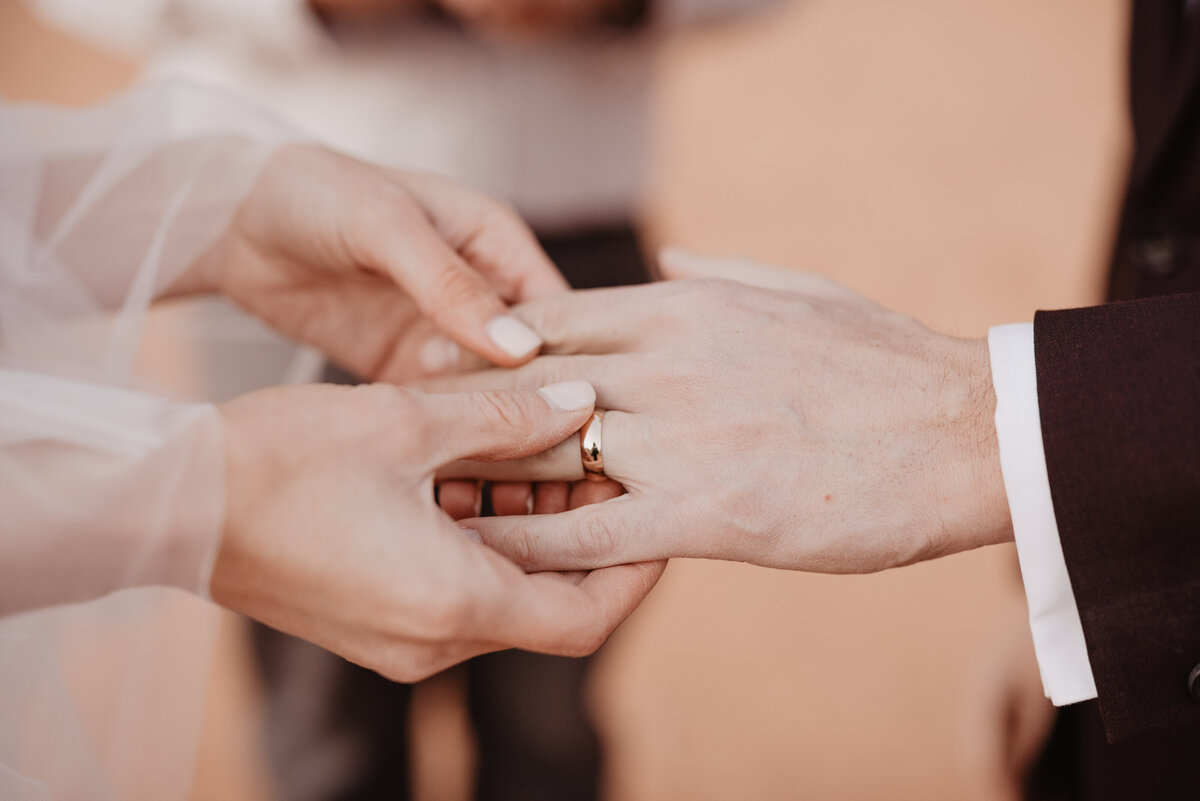 Utah elopement photographer captures bride placing ring on groom's finger