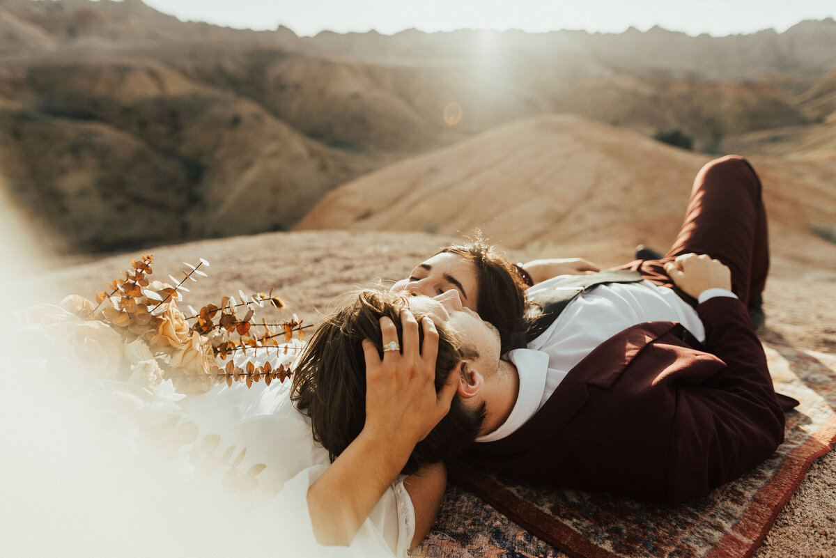 Bride and groom laying on a rug in the Badlands