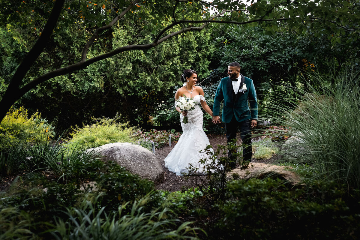 Bride and groom have an intimate walk in the secret garden at The Gardens at Uncanoonuc Mountain in Goffstown NH by Lisa Smith Photography