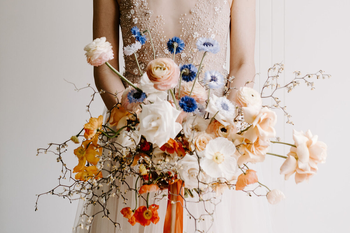 Queenstown elopement bouquet with poppies, roses, cornflower and orange silk ribbon