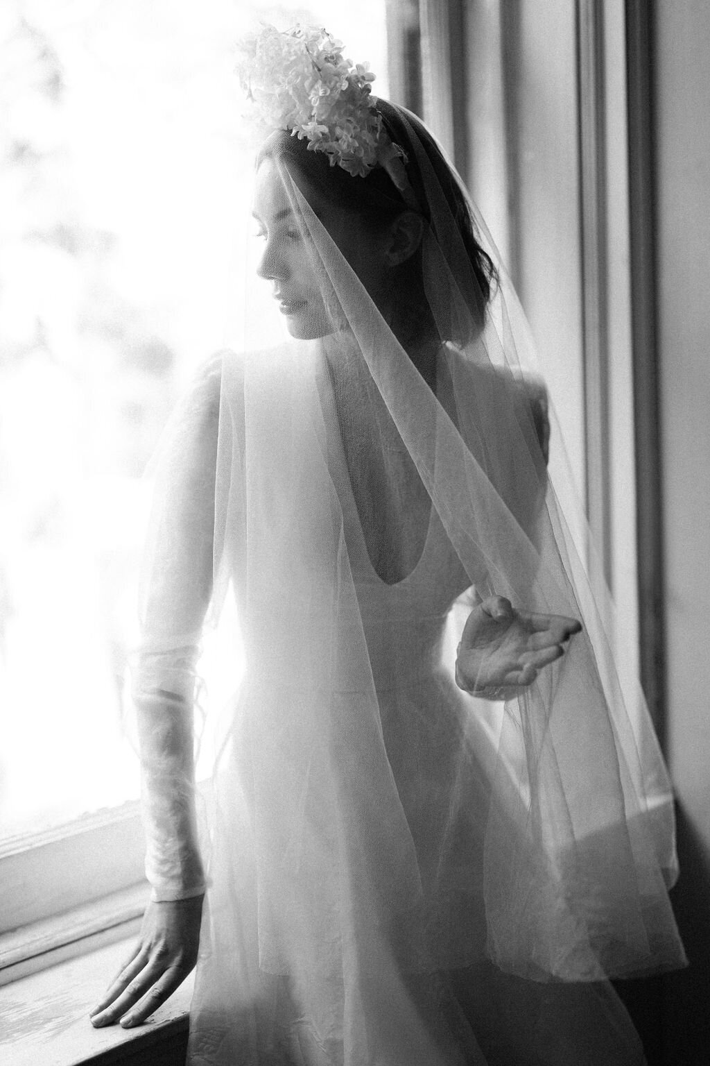 black and white portrait of bride sitting in window sill