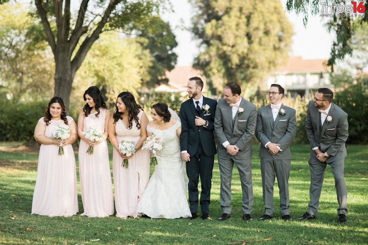 Bridal Party turn to one of the Bridesmaids while laughing