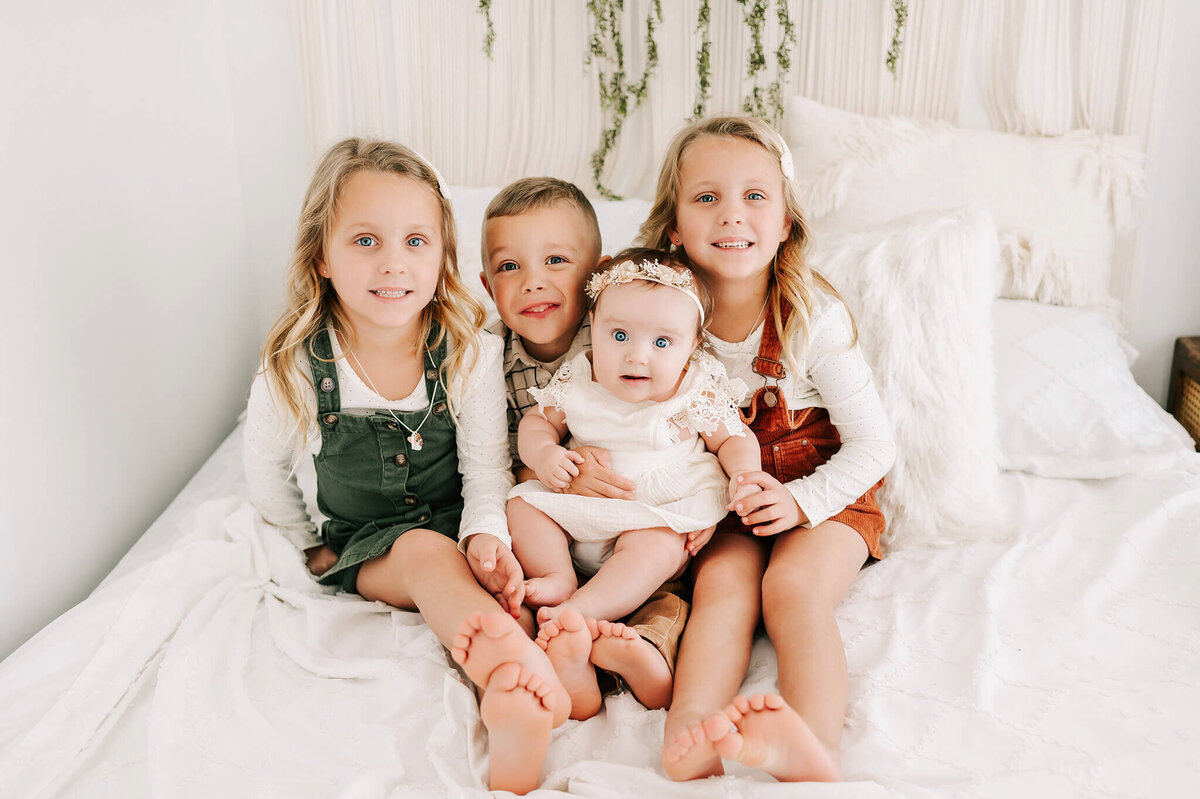 kids cuddling in bed smiling during Branson MO family photography
