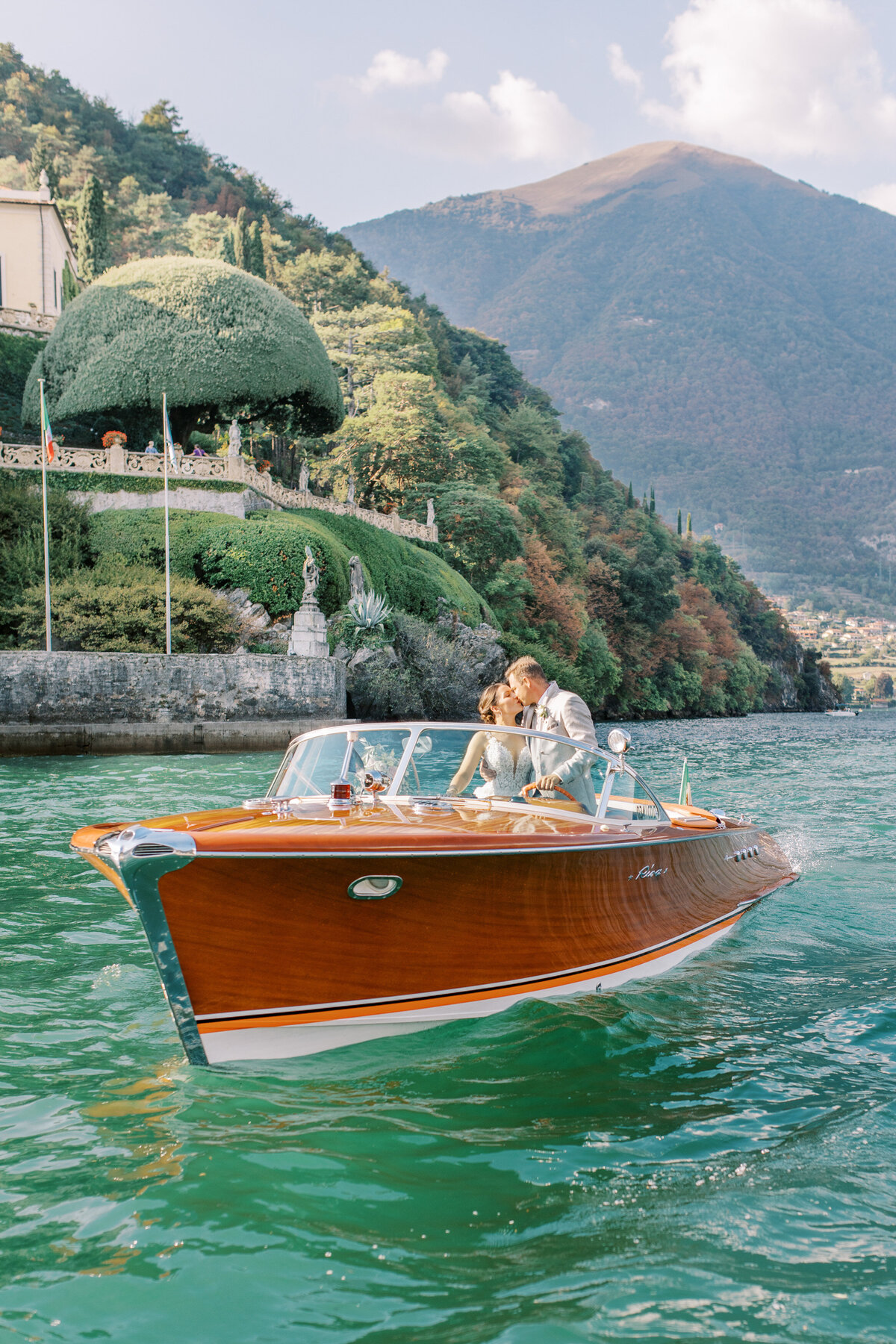 Bröllopspar i en Rivabåt utanför Villa Balbianello Como