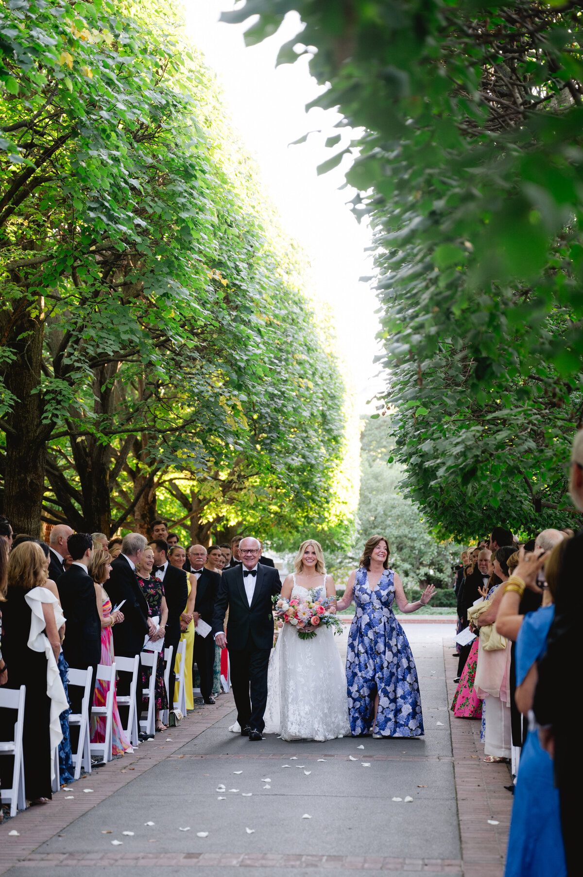 Guests seated along a tree-lined aisle for a wedding ceremony at the Chicago Botanic Gardens.