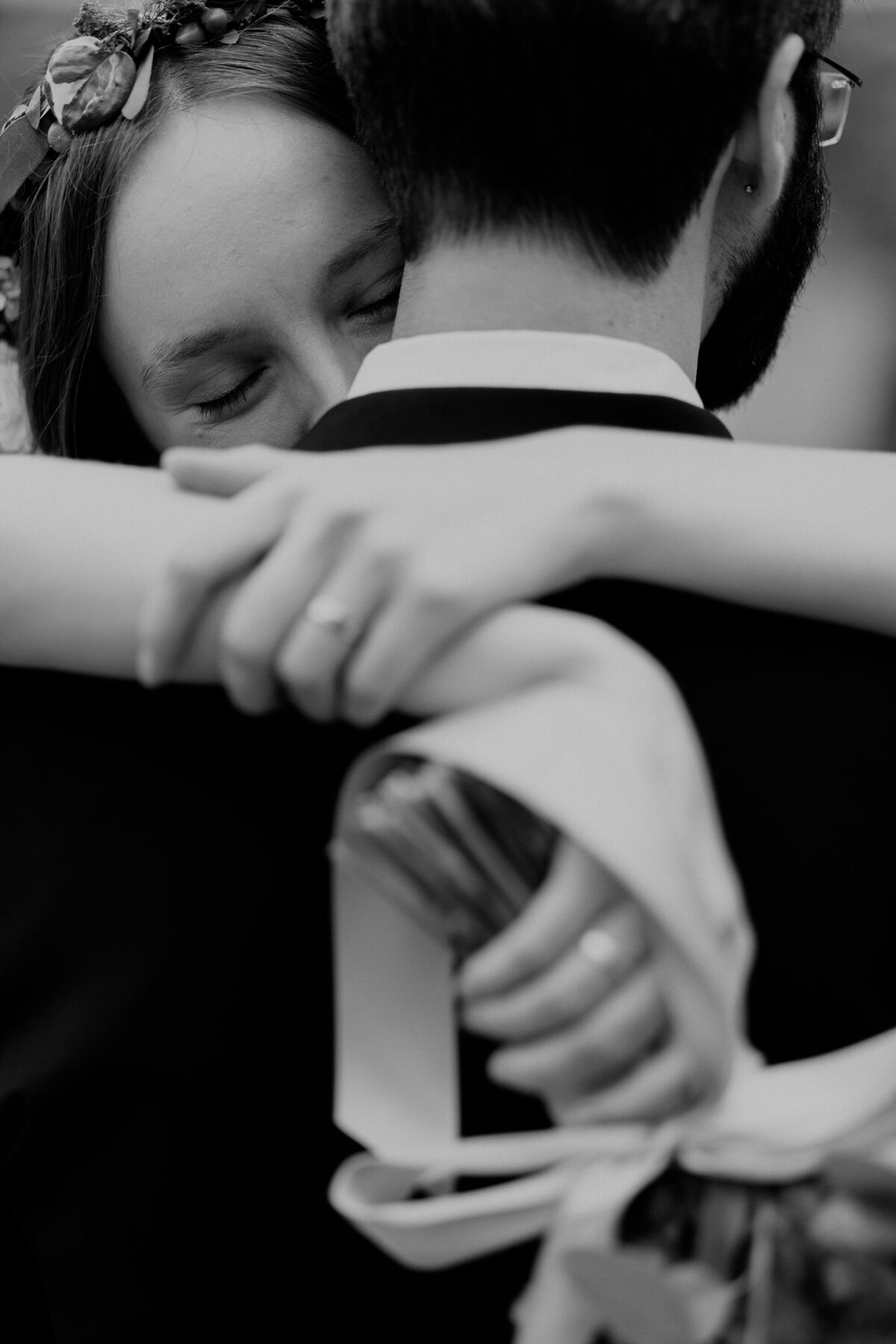 A black and white photo of a bride and groom embracing during their wedding at Red Rocks Trading Post.