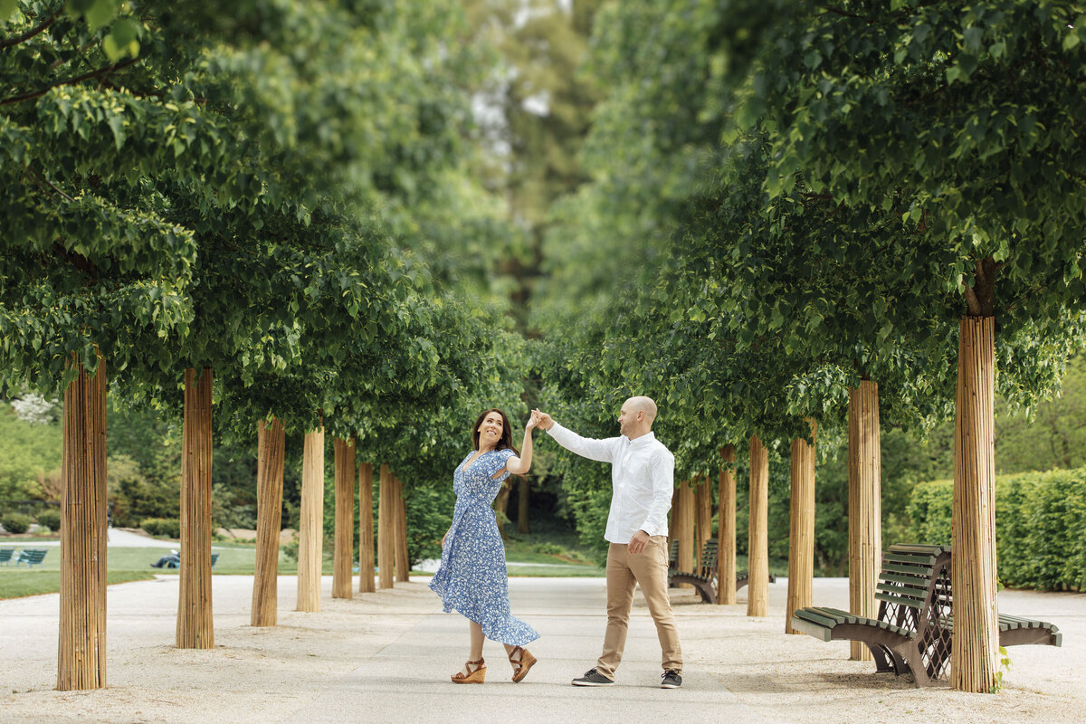 Longwood Gardens | Couple dancing among tall trees during engagement session | Kennett Square, Pennsylvania
