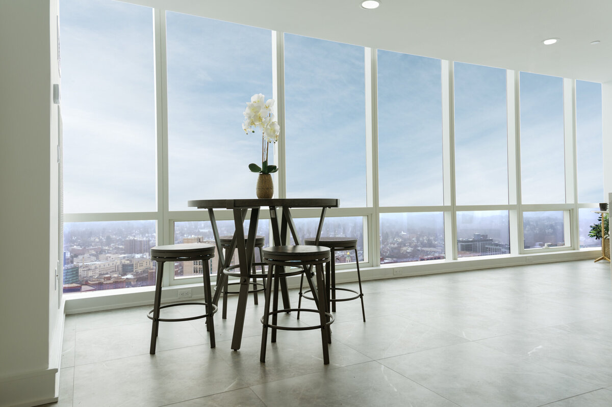 tall table with bar stools against windows
