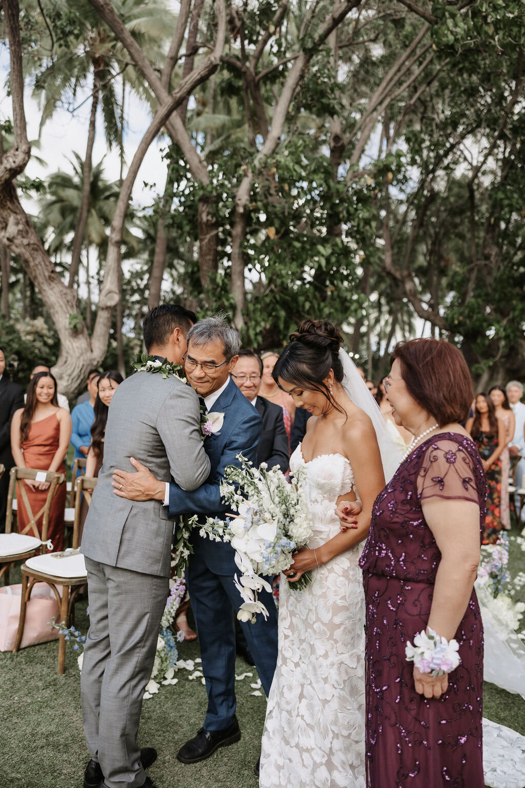 wedding at lanikuhonua ceremony, groom hugging brides father