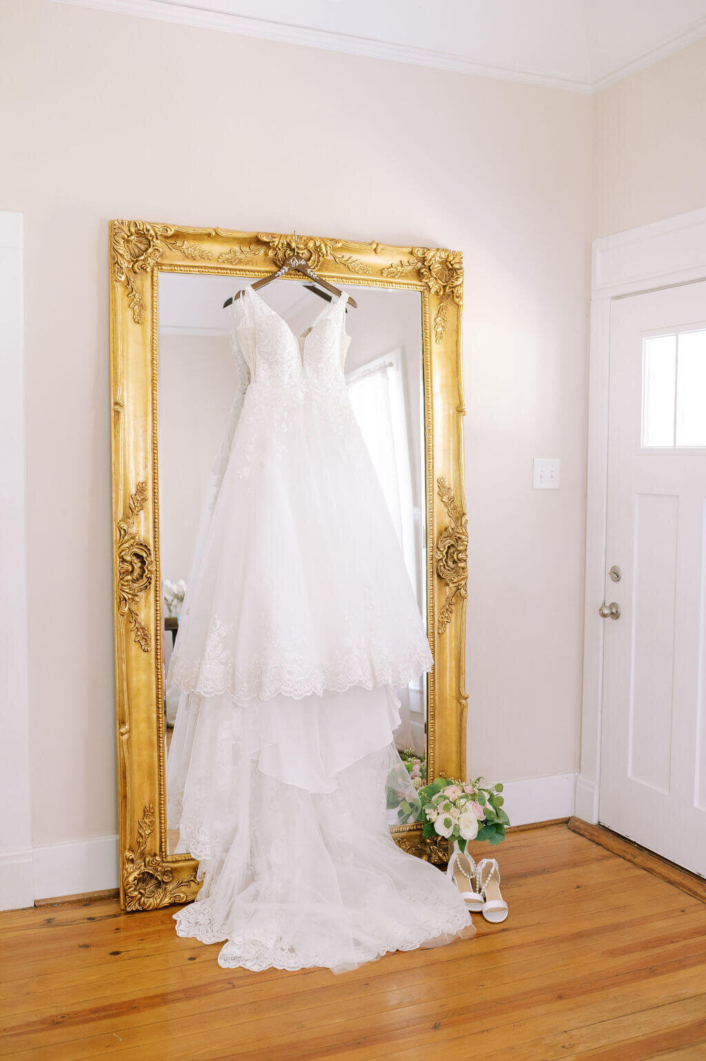 Wedding dress hanging up in front of mirror