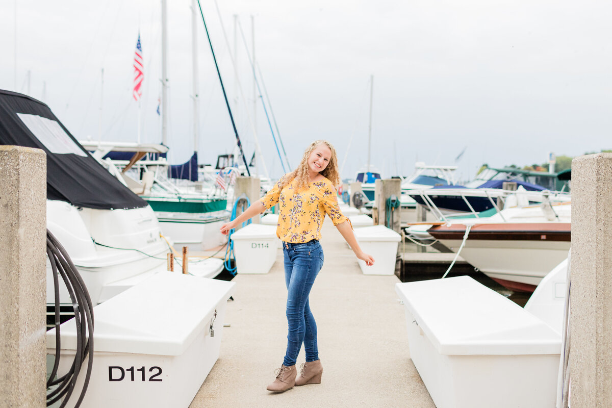 senior girl spinning on a boat dock marina