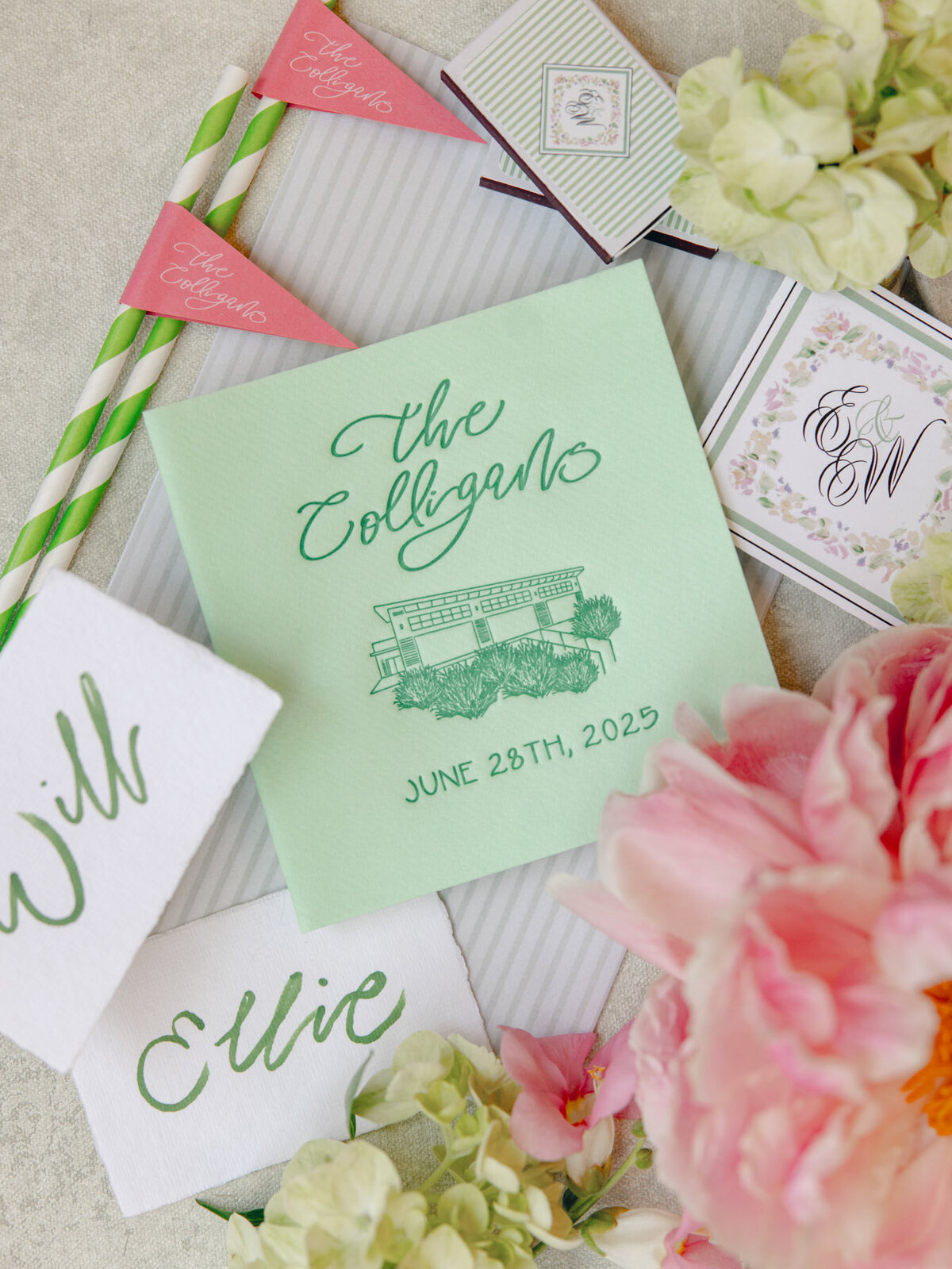 Mint green cocktail napkin with a custom venue drawing and calligraphy details also featuring florals, cocktail straws and placecards representing full service design and calligraphy by Life in Letters.