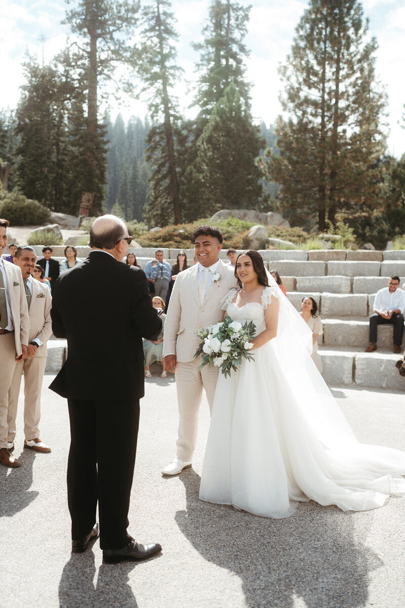 Bride and Groom stand before their pastor during their Glacier Point Amphitheater Wedding 