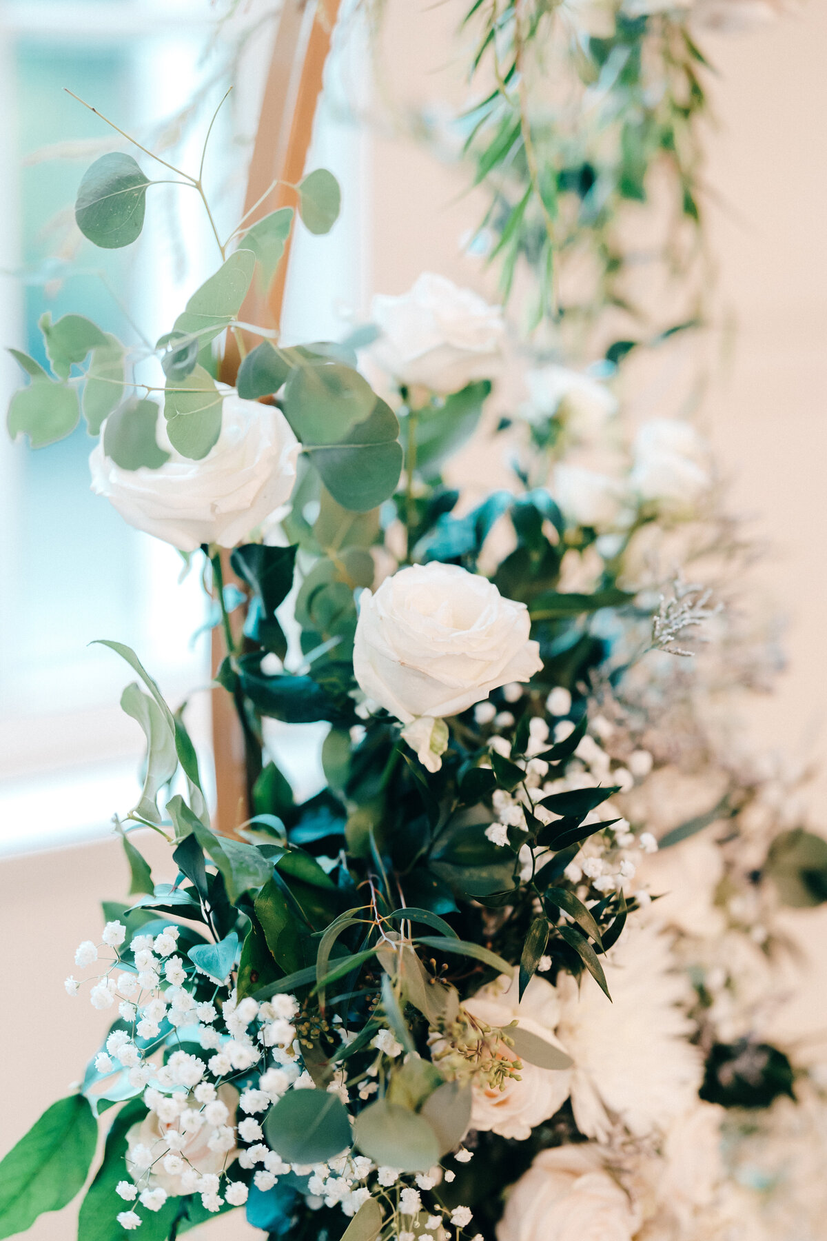 Closeup of white wedding flower arrangements with greenery.