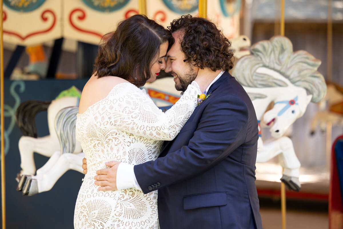 A bride and groom standing forehead to forehead