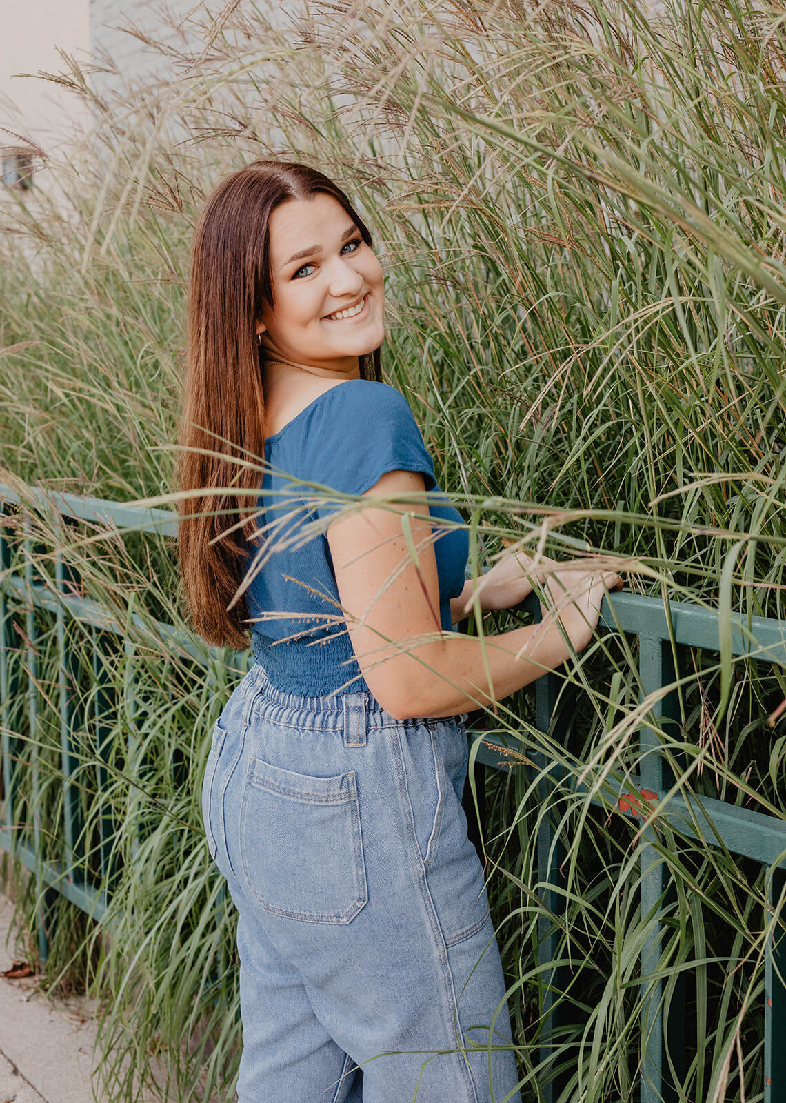 woman posing by fence