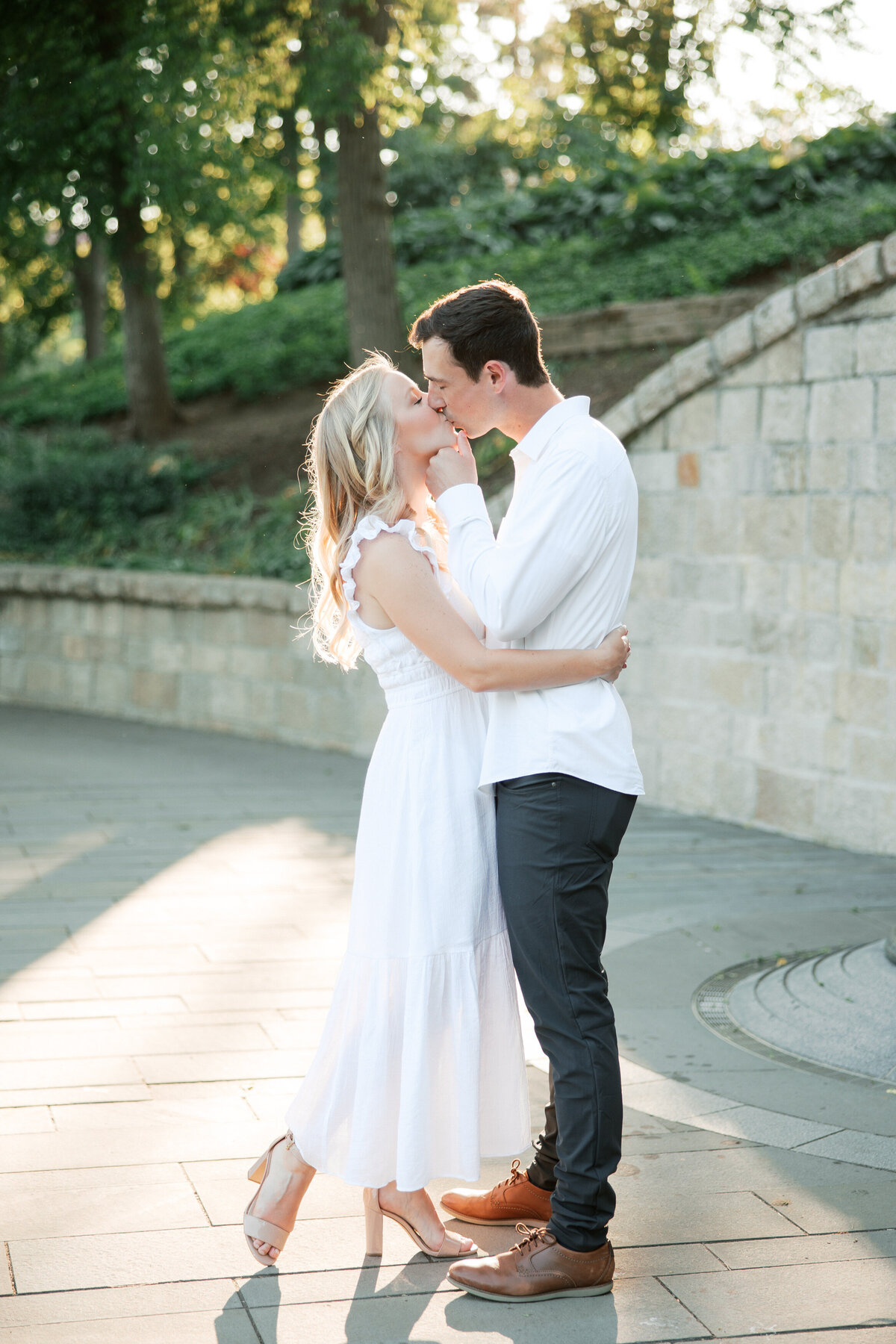 Sunset kiss by stone wall in Columbus, engagement photo by Philly-based wedding photographer.