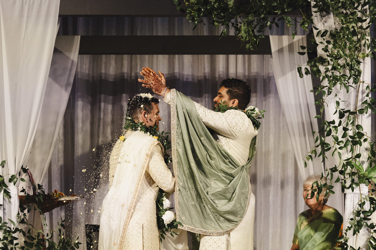 A person pouring rice over their partner's head at their wedding ceremony 