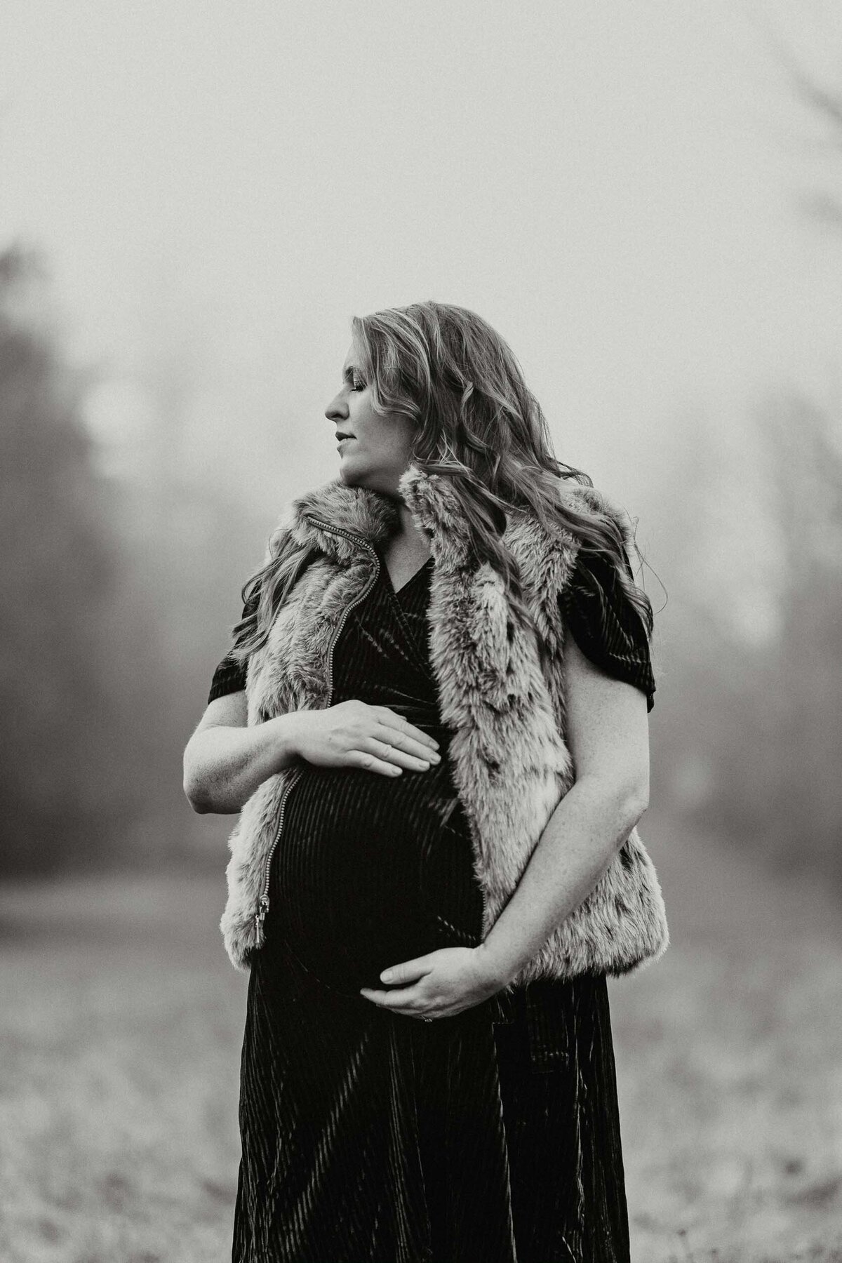 Pregnant woman gently holding her belly with closed eyes, embracing the peaceful moment of anticipation.