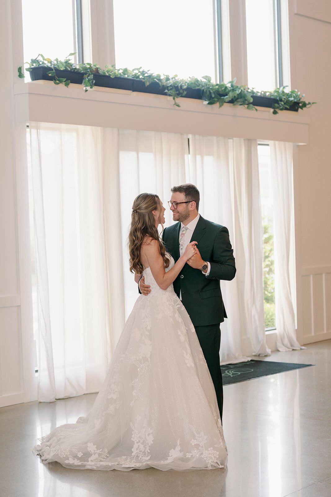 Bride and groom sharing their first dance in the reception hall at The Ivy House wedding venue in Saugatuck MI.