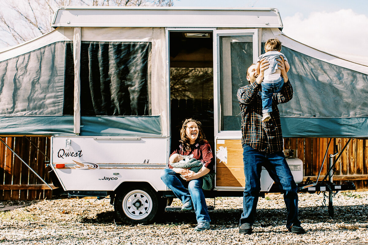 family of four hang out in front of a camper